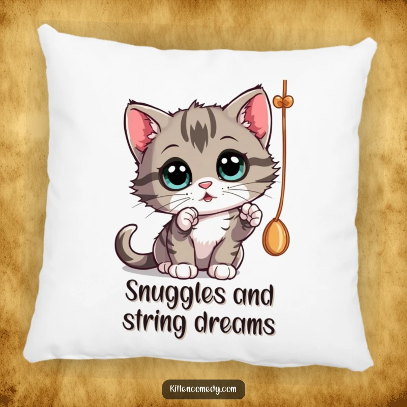 Funny curious kitten batting at a dangling string, a soft pillow for cuddles and funny gifts.
