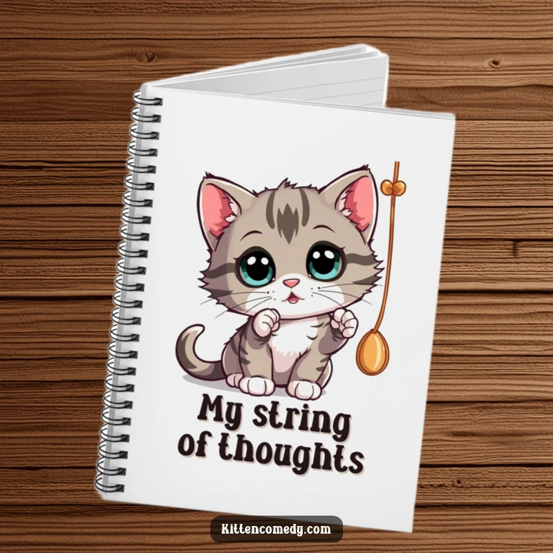 Funny curious kitten batting at a dangling string, a notebook for journaling curious thoughts.