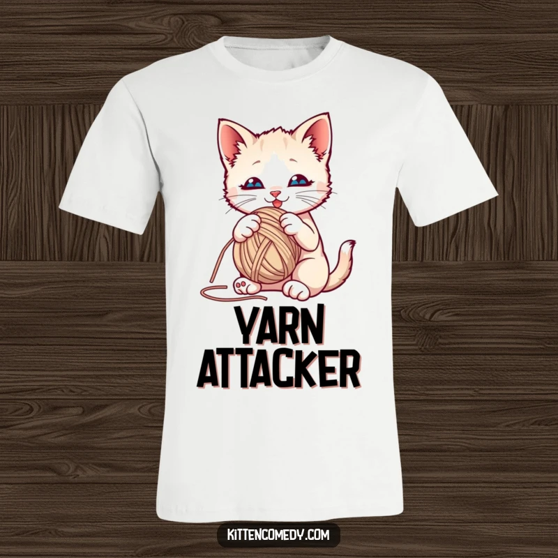 Funny kitten playfully batting at a bright yarn ball on a t-shirt, capturing a moment of cute cat antics.